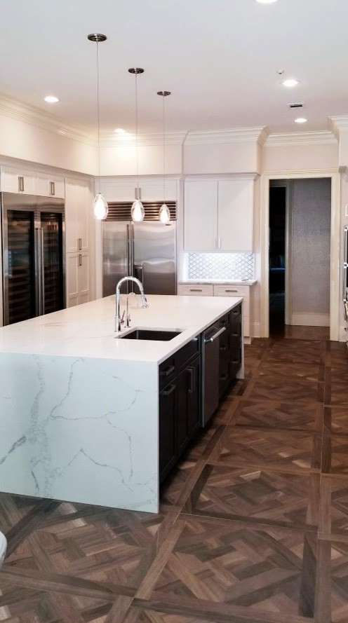 Example of a large transitional u-shaped dark wood floor and brown floor eat-in kitchen design in Miami with a farmhouse sink, shaker cabinets, white cabinets, stainless steel appliances, an island, white countertops, marble countertops and gray backsplash
