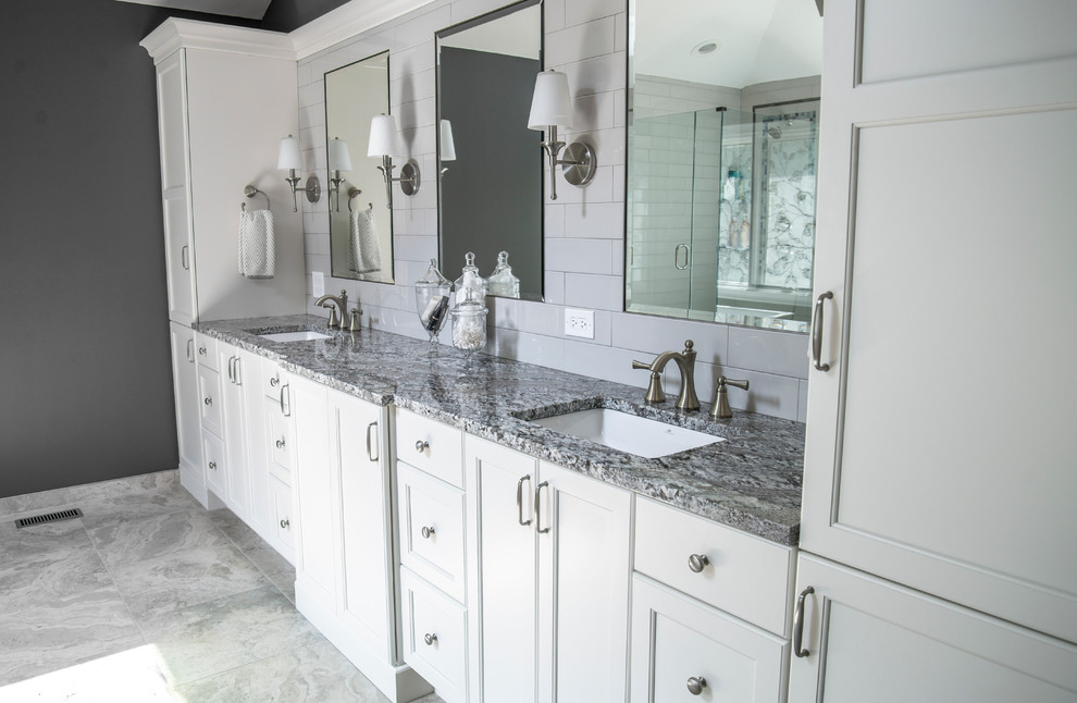 Mid-sized transitional master bathroom in Chicago with flat-panel cabinets, white cabinets, a freestanding tub, a corner shower, a two-piece toilet, gray tile, subway tile, grey walls, porcelain floors, an undermount sink and granite benchtops.