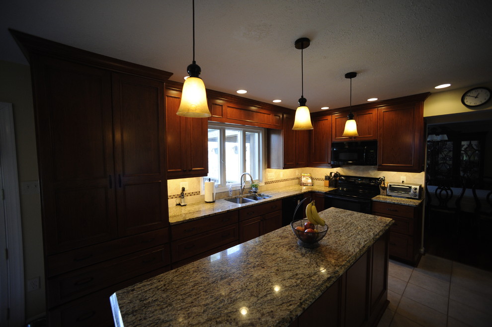Enclosed kitchen - mid-sized transitional u-shaped limestone floor enclosed kitchen idea in Baltimore with an undermount sink, beaded inset cabinets, dark wood cabinets, granite countertops, beige backsplash, stone tile backsplash, stainless steel appliances and a peninsula