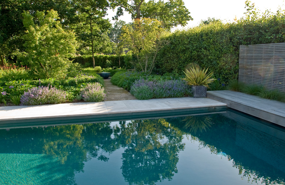 Large traditional backyard partial sun formal garden in Sussex with natural stone pavers for summer.