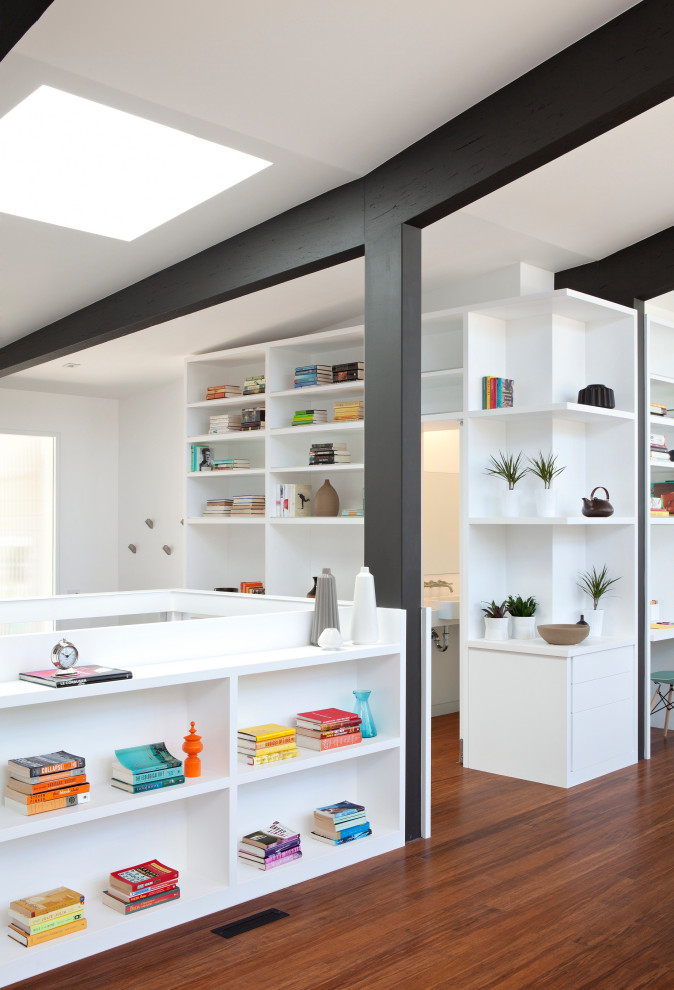 Idéer för att renovera ett funkis hobbyrum, med vita väggar, mellanmörkt trägolv, ett inbyggt skrivbord och brunt golv