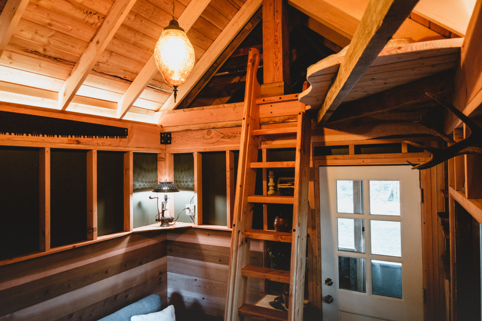 Kleines Uriges Wohnzimmer im Loft-Stil mit gebeiztem Holzboden, grünem Boden, freigelegten Dachbalken und Wandpaneelen in Seattle