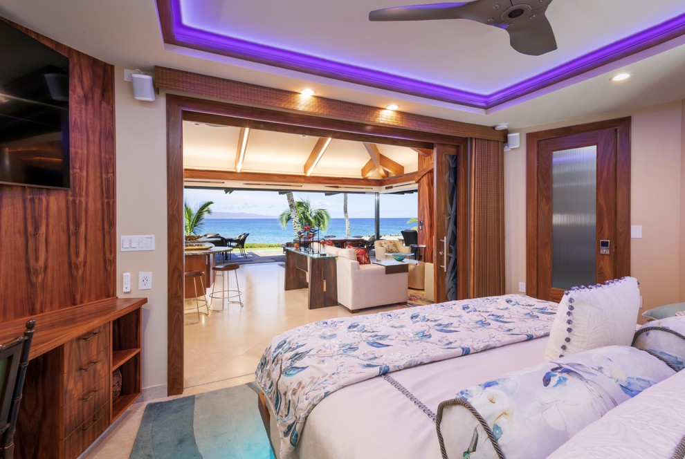 Photo of a tropical master bedroom in Hawaii with limestone floors and beige floor.