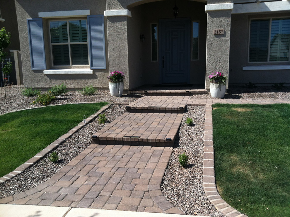 This is an example of a large traditional backyard partial sun garden in Phoenix with a garden path and concrete pavers.