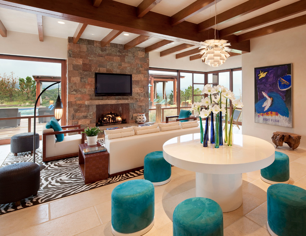 This is an example of a large contemporary open concept family room in Albuquerque with white walls, limestone floors, a standard fireplace, a stone fireplace surround, a built-in media wall and beige floor.