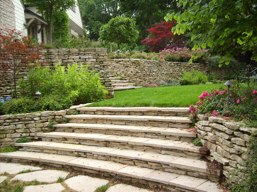 Photo of a traditional sloped full sun garden for summer in Columbus with natural stone pavers.