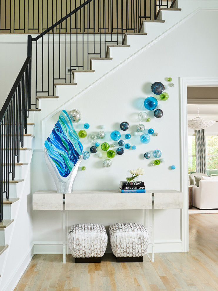 Inspiration for a large coastal light wood floor and beige floor foyer remodel in Other with white walls