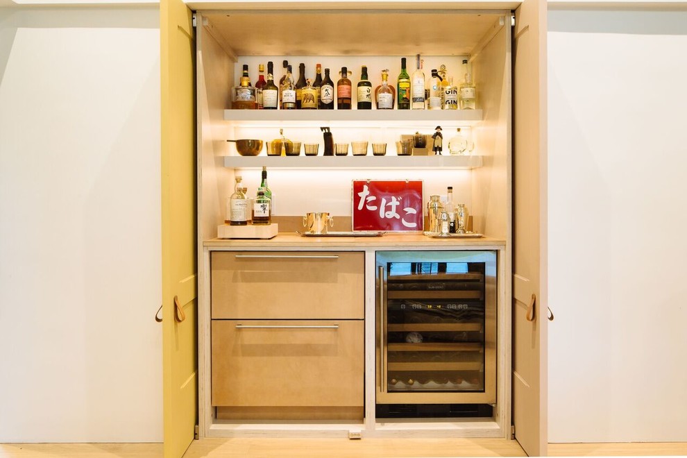 Inspiration for a small contemporary single-wall wet bar in San Diego with no sink, flat-panel cabinets, light wood cabinets, wood benchtops and light hardwood floors.