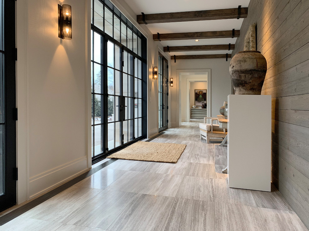 Large modern foyer in Chicago with grey walls, light hardwood floors, a double front door, a black front door, brown floor, exposed beam and planked wall panelling.