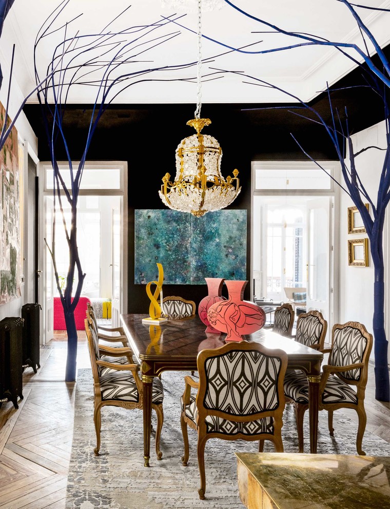Inspiration for a large eclectic separate dining room in Madrid with black walls and medium hardwood floors.