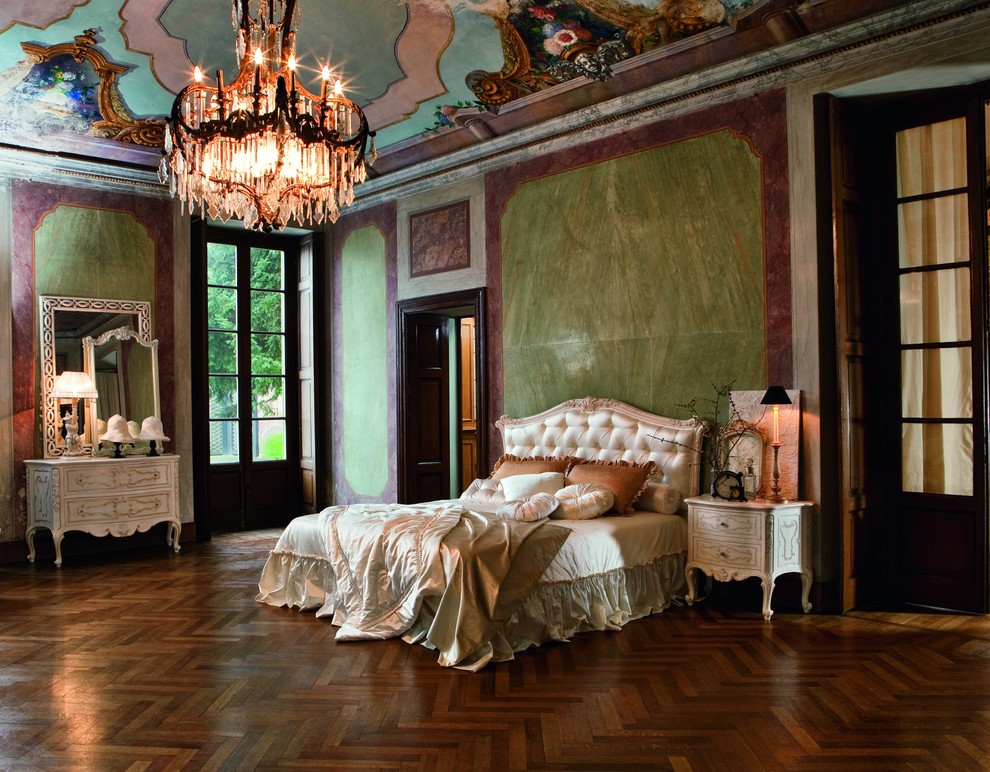 Photo of a large traditional master bedroom in London with green walls, medium hardwood floors and no fireplace.
