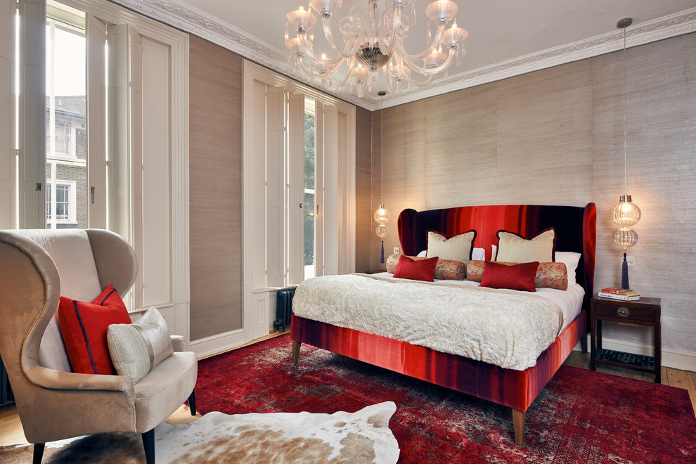 This is an example of an eclectic master bedroom in London with beige walls, medium hardwood floors and brown floor.