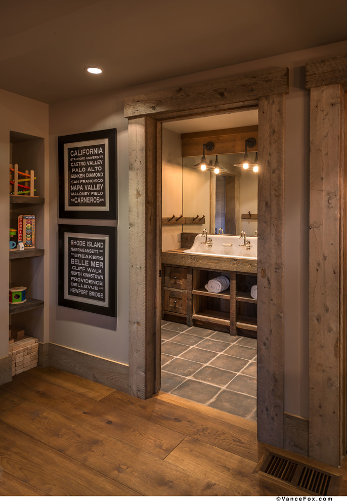 Photo of a mid-sized country kids bathroom in Sacramento with furniture-like cabinets, medium wood cabinets, grey walls, medium hardwood floors, a trough sink, wood benchtops and brown floor.