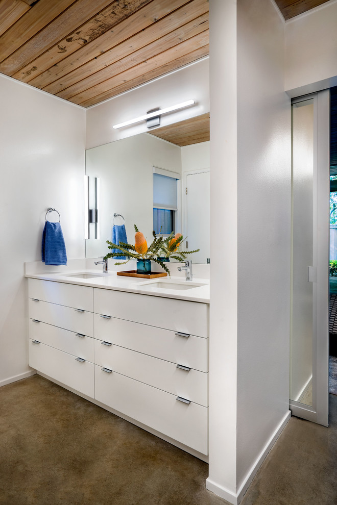 Inspiration for a small midcentury 3/4 bathroom in Portland with flat-panel cabinets, white cabinets, concrete floors, engineered quartz benchtops, white walls, an undermount sink and grey floor.