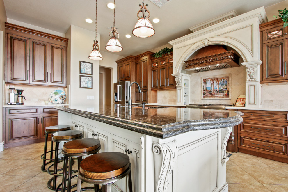 Inspiration for a large timeless porcelain tile and beige floor kitchen remodel in Los Angeles with an undermount sink, raised-panel cabinets, quartz countertops, beige backsplash, travertine backsplash, stainless steel appliances and an island