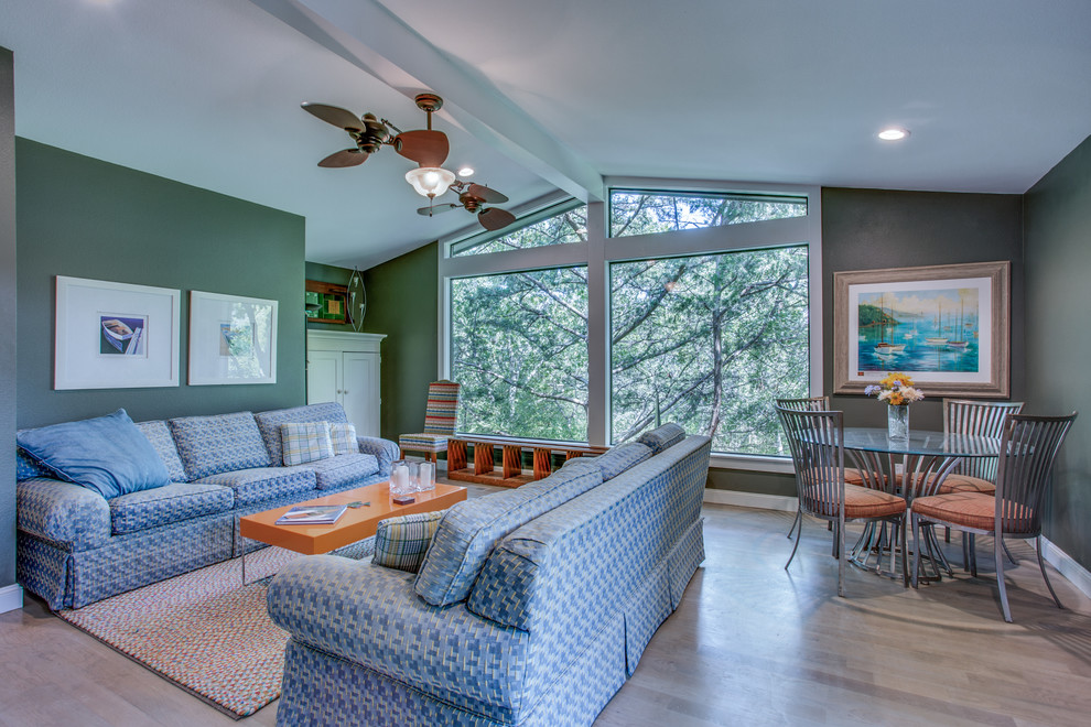 Mid-sized midcentury enclosed family room in Dallas with green walls, medium hardwood floors, a wall-mounted tv and brown floor.