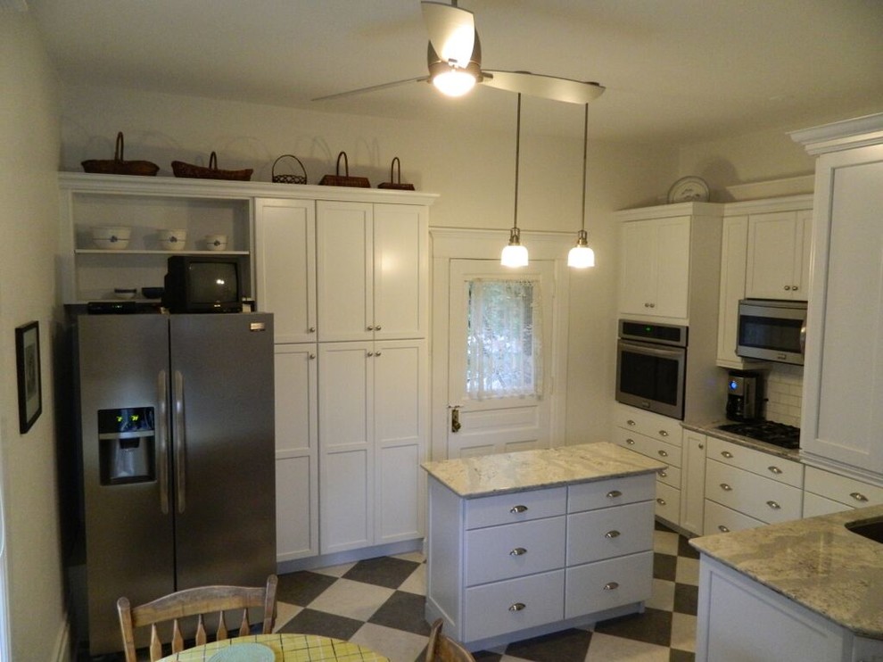 Enclosed kitchen - transitional enclosed kitchen idea in Toronto with an undermount sink, recessed-panel cabinets, quartz countertops, white backsplash, ceramic backsplash, stainless steel appliances and an island
