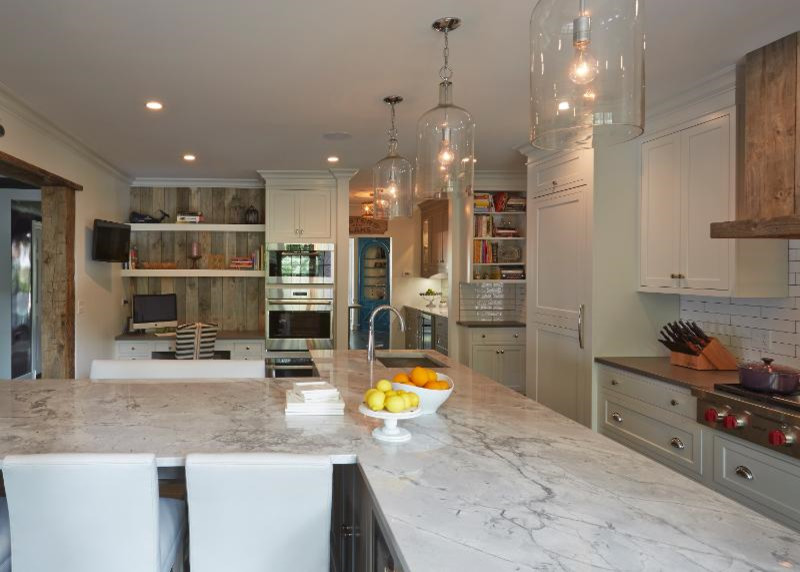 Inspiration for a mid-sized country eat-in kitchen in Chicago with a drop-in sink, recessed-panel cabinets, white cabinets, marble benchtops, white splashback, ceramic splashback, stainless steel appliances, porcelain floors, multiple islands and brown floor.