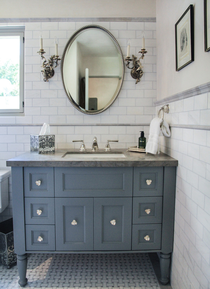 This is an example of a traditional bathroom in Santa Barbara with an undermount sink, blue cabinets and grey benchtops.