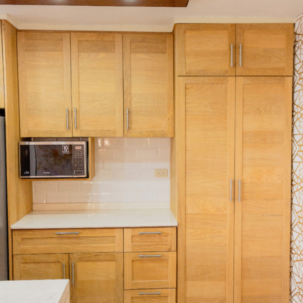 Mountain style brown floor eat-in kitchen photo with brown cabinets, quartzite countertops, white backsplash, subway tile backsplash, stainless steel appliances and white countertops