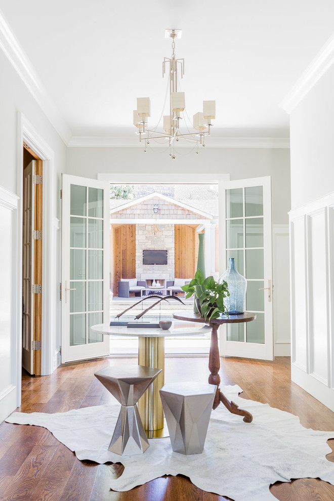 Inspiration for a mid-sized transitional medium tone wood floor foyer remodel with white walls