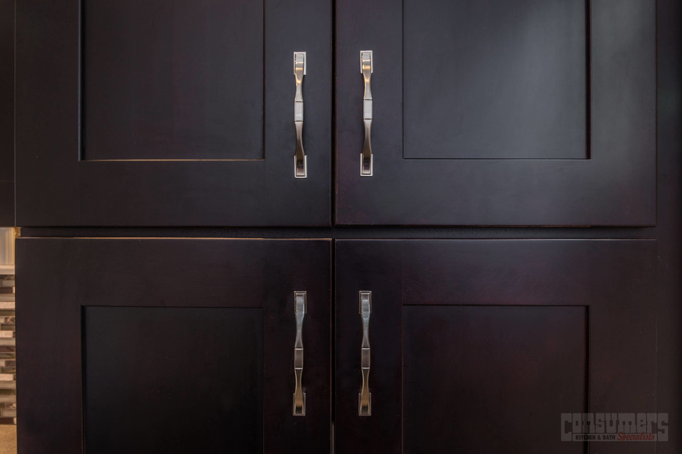 Inspiration for a large l-shaped eat-in kitchen remodel in New York with an undermount sink, shaker cabinets, dark wood cabinets, quartz countertops, multicolored backsplash, stainless steel appliances and no island
