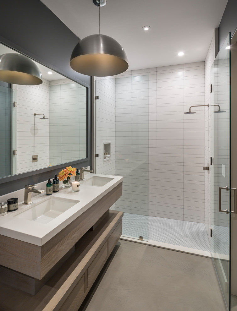 This is an example of an expansive contemporary bathroom in San Francisco with flat-panel cabinets, brown cabinets, a two-piece toilet, white tile, ceramic tile, black walls, ceramic floors, an undermount sink, marble benchtops, brown floor, a hinged shower door and white benchtops.