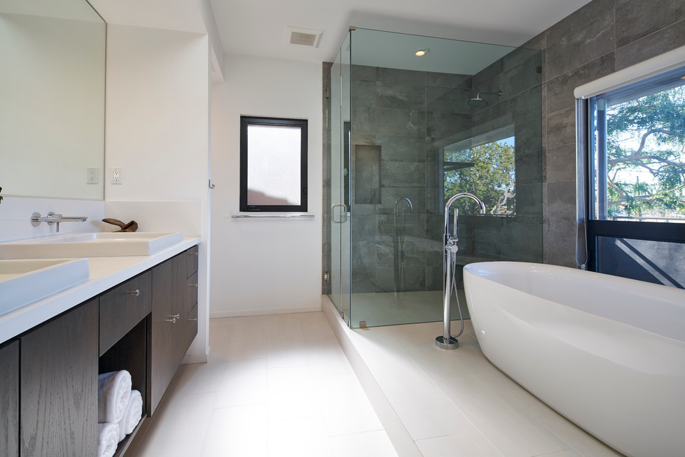 Large contemporary master bathroom in Los Angeles with flat-panel cabinets, dark wood cabinets, a freestanding tub, white tile, porcelain tile, a vessel sink, engineered quartz benchtops, a curbless shower, white walls, porcelain floors and white benchtops.