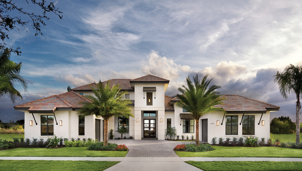 Photo of an expansive tropical one-storey stucco white exterior in Tampa with a gable roof.