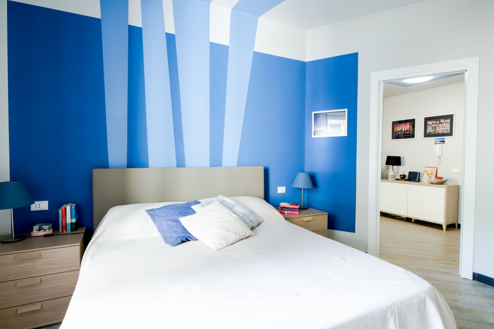 Imagen de dormitorio principal contemporáneo con paredes azules, suelo laminado, suelo beige y todos los tratamientos de pared