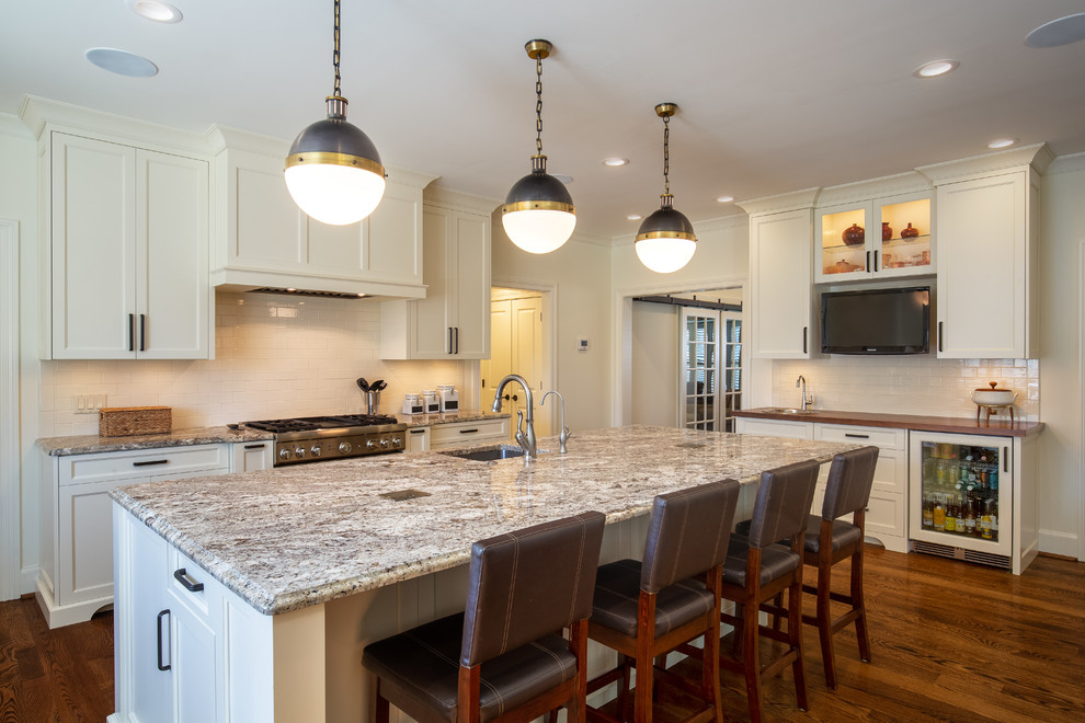 Transitional eat-in kitchen in Cincinnati with an undermount sink, shaker cabinets, white cabinets, granite benchtops, white splashback, porcelain splashback, stainless steel appliances, medium hardwood floors, with island and multi-coloured benchtop.