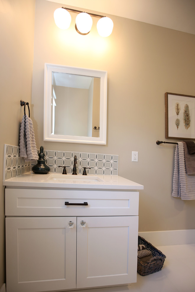 This is an example of a mid-sized transitional bathroom in Denver with white cabinets, an alcove tub, a shower/bathtub combo, porcelain floors, an undermount sink, white floor, white benchtops, recessed-panel cabinets, a two-piece toilet, gray tile, ceramic tile, beige walls and quartzite benchtops.
