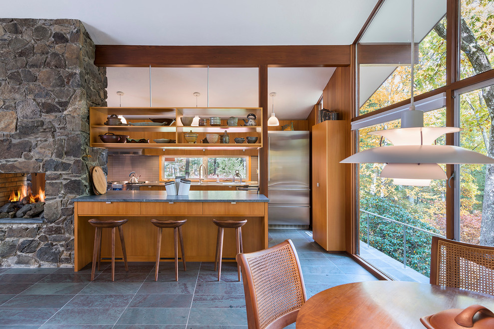 Large midcentury galley eat-in kitchen in Boston with a double-bowl sink, medium wood cabinets, grey splashback, stone tile splashback, stainless steel appliances, slate floors, flat-panel cabinets and no island.