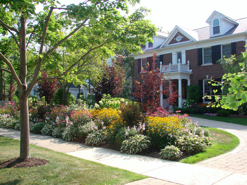 Design ideas for a mid-sized traditional front yard partial sun formal garden in Chicago with a garden path and natural stone pavers.