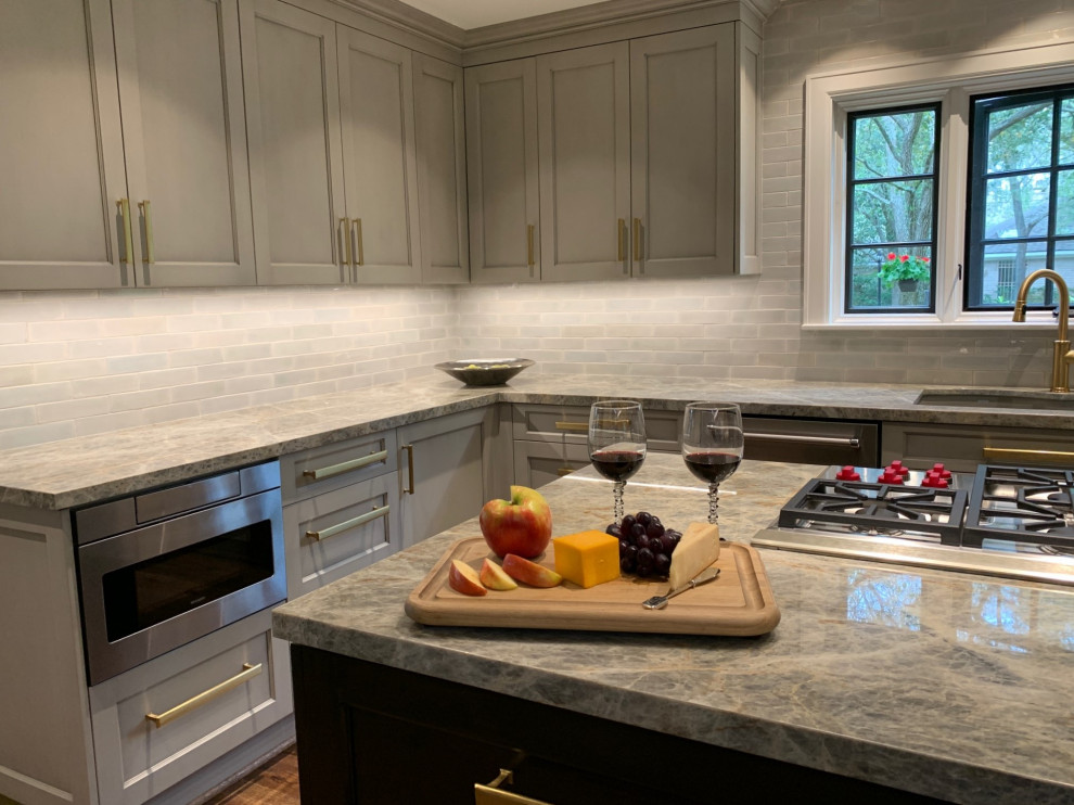 Inspiration for an expansive modern u-shaped open plan kitchen in Houston with an undermount sink, shaker cabinets, grey cabinets, quartzite benchtops, grey splashback, subway tile splashback, stainless steel appliances, medium hardwood floors, with island, brown floor and blue benchtop.