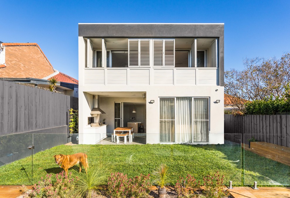 Contemporary two-storey stucco white house exterior in Newcastle - Maitland with a flat roof.