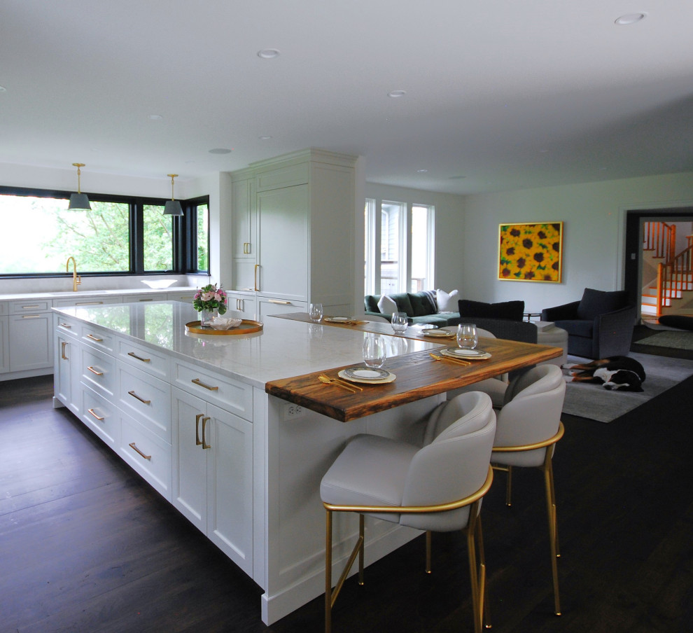 Inspiration for a large transitional l-shaped dark wood floor and brown floor open concept kitchen remodel in Philadelphia with an undermount sink, shaker cabinets, beige cabinets, wood countertops, beige backsplash, porcelain backsplash, paneled appliances, an island and brown countertops