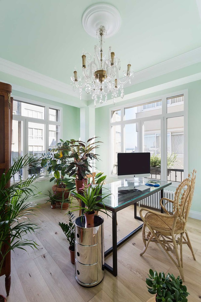 Photo of a mid-sized transitional study room in Other with green walls, a freestanding desk, beige floor, light hardwood floors and no fireplace.