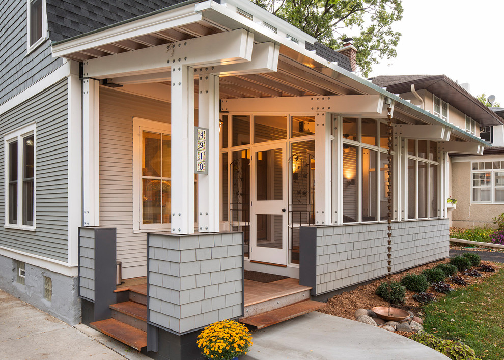 Inspiration for a traditional front yard screened-in verandah in Minneapolis with a roof extension.