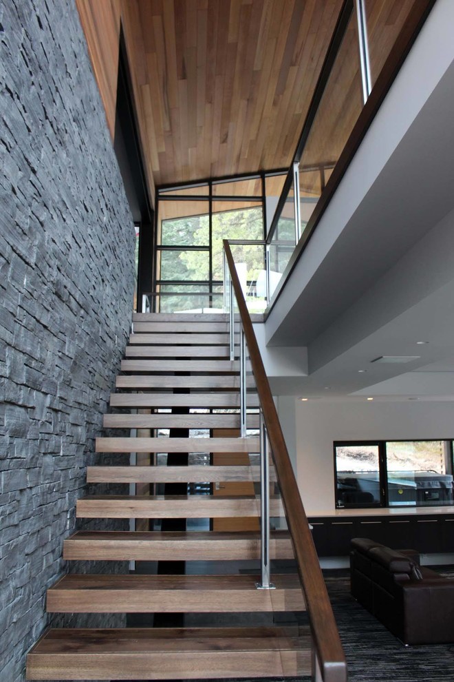 Design ideas for a mid-sized modern wood l-shaped staircase in Calgary with wood risers and glass railing.