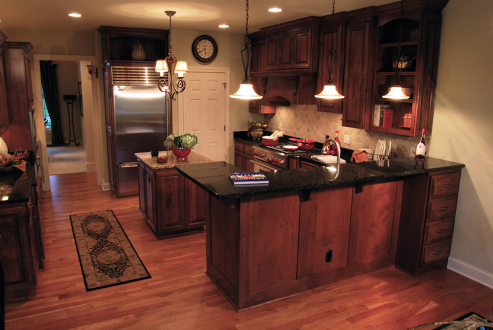 Inspiration for a traditional kitchen in Milwaukee with beaded inset cabinets, medium wood cabinets, stainless steel appliances, medium hardwood floors and with island.