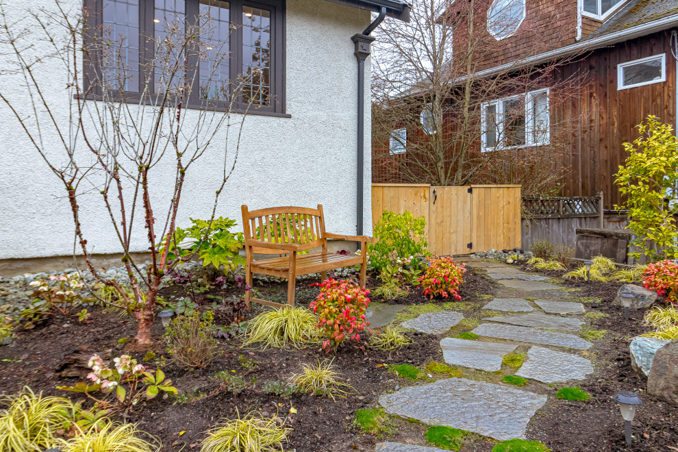 Inspiration for a mid-sized transitional drought-tolerant and partial sun front yard stone and wood fence walkway.