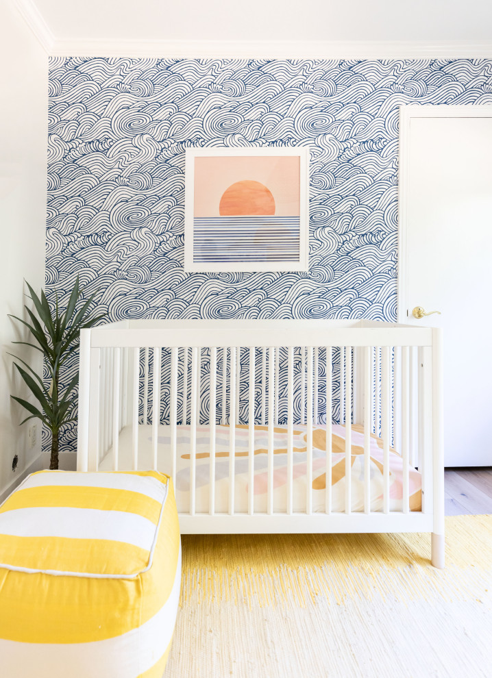 Réalisation d'une petite chambre de bébé neutre marine avec un mur jaune et du papier peint.