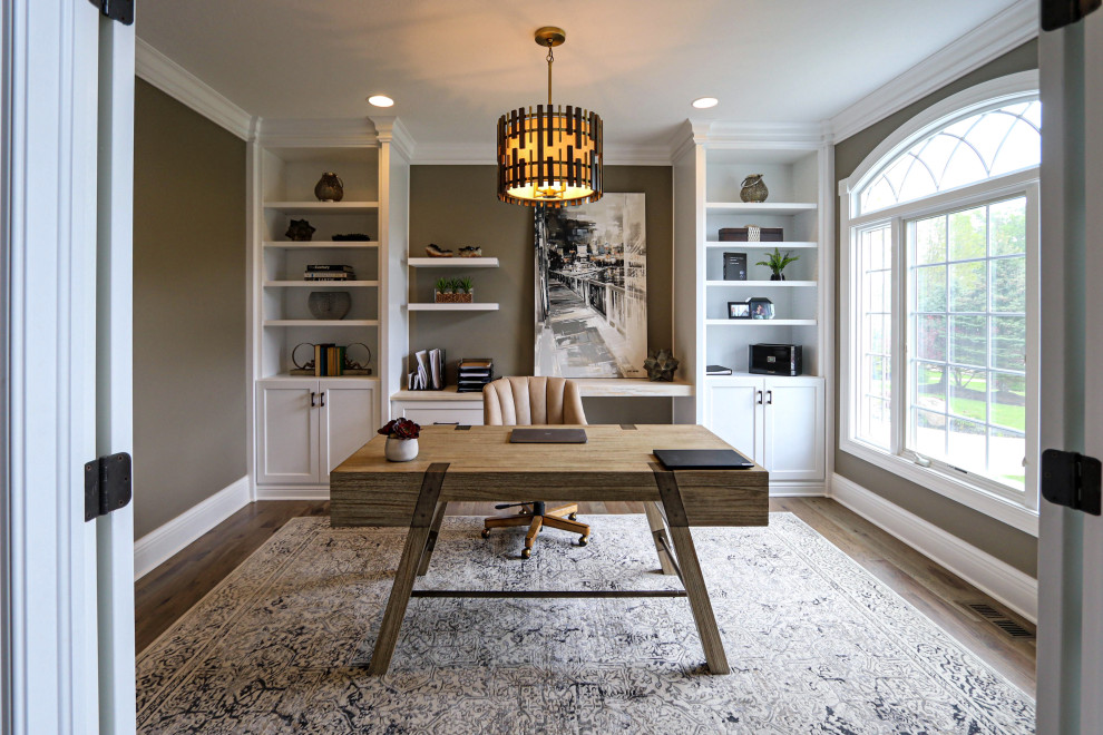 Diseño de despacho tradicional renovado de tamaño medio con paredes beige, suelo de madera en tonos medios, escritorio independiente y suelo marrón