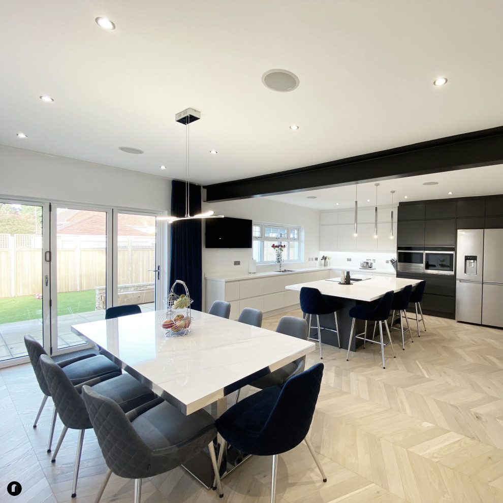 Large contemporary open plan dining room in Glasgow with white walls, medium hardwood flooring and feature lighting.