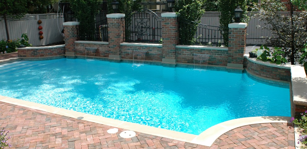 Pool fountain - large mediterranean backyard brick and custom-shaped pool fountain idea