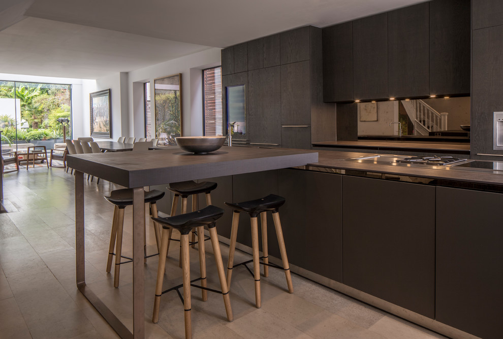 This is an example of a mid-sized contemporary single-wall open plan kitchen in London with flat-panel cabinets, brown cabinets, metallic splashback, mirror splashback, stainless steel appliances, with island and grey floor.