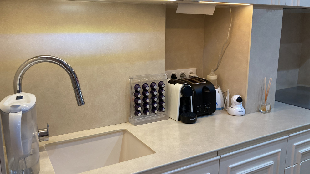Bild på ett mellanstort funkis beige linjärt beige kök och matrum, med en undermonterad diskho, luckor med upphöjd panel, beige skåp, bänkskiva i koppar, beige stänkskydd, integrerade vitvaror och beiget golv