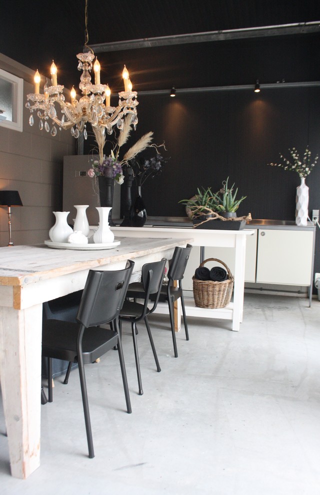 This is an example of a contemporary dining room in Amsterdam with black walls.