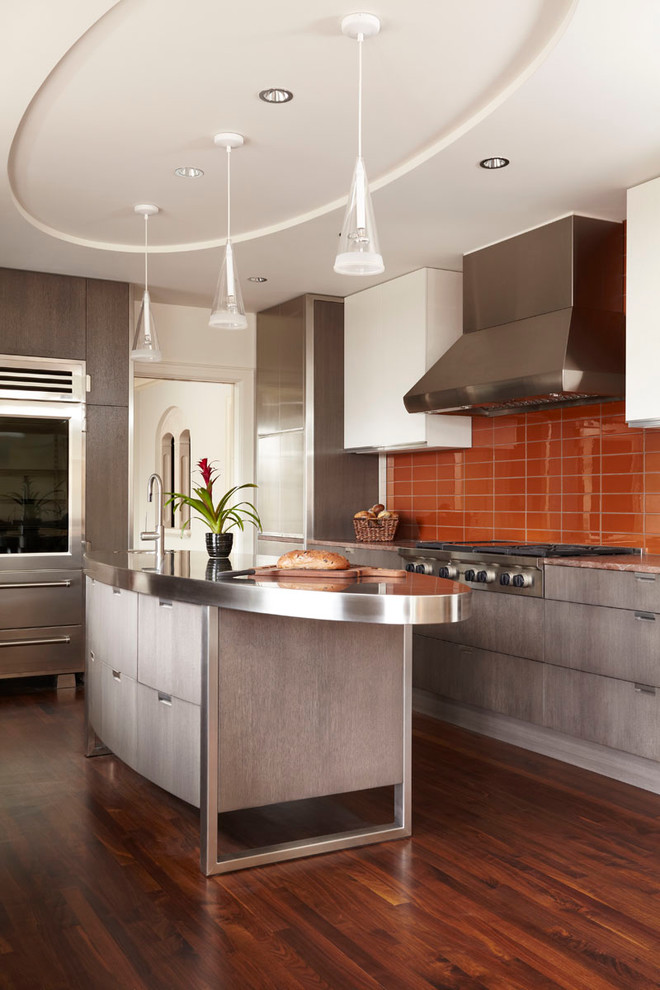 Inspiration for a contemporary kitchen in Minneapolis with stainless steel appliances, stainless steel benchtops, orange splashback, flat-panel cabinets and grey cabinets.